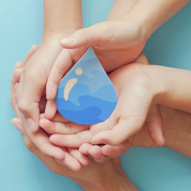 Hands hold a water drop on a teal background.