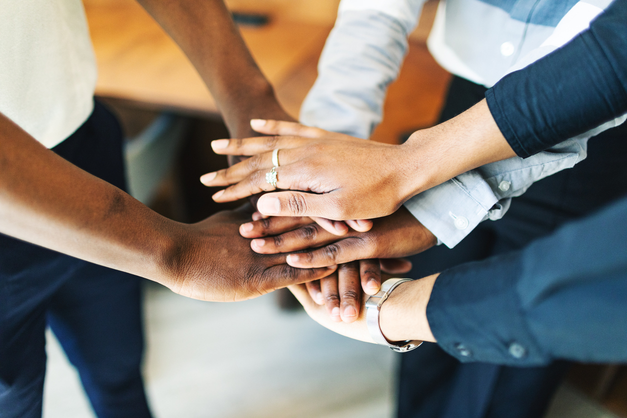 Business team putting hands together at the office