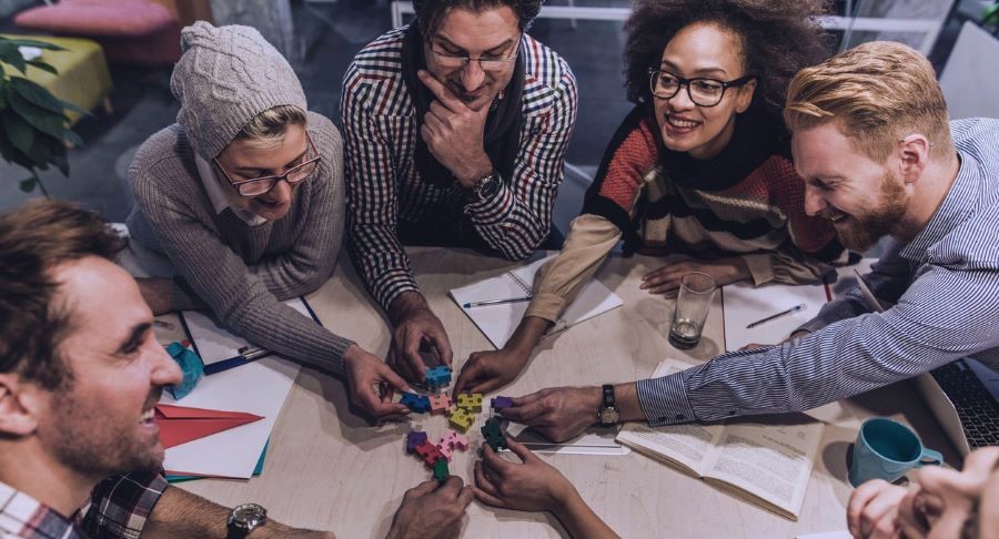 Adults working on solving a puzzle as a team.