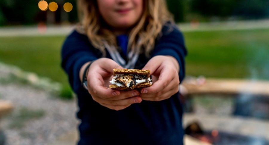 Little girl holding a smore in her hands.